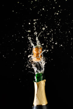 Cork flies out of champagne bottle. Festive theme