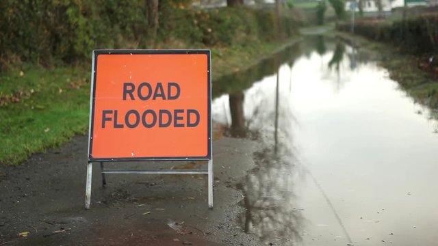 Road flooded sign after big rain storm closed road 