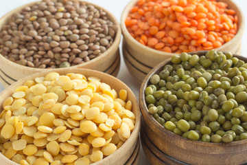 Four varieties of lentils in wooden bowls