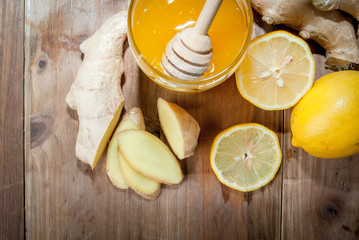 Selection products for making ginger tea: ginger, honey, lemon. On wooden table, top view, copy space