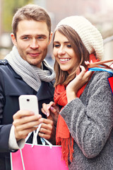 Couple shopping in the city with smartphone