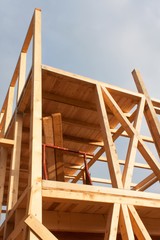 Obraz premium Sunny evening at the construction site of a wooden house. Unfinished house. 