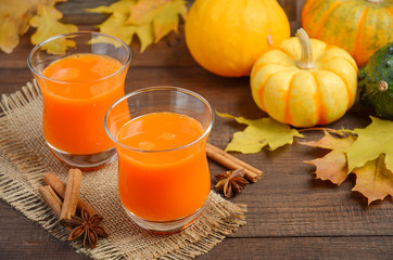 Healthy pumpkin juice in glasses on autumn background, selective focus