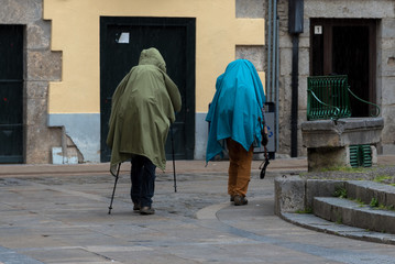 Zwei Pilger mit Regenschutz auf dem Jakobsweg in Spanien