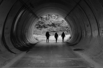 Drei Pilger mit Rucksäcken in einer Strassenunterführung am Jakobsweg in Spanien