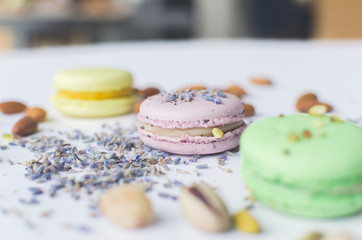yellow, green and purple macaron cakes or macaroon on white background, sweet and colorful dessert, above, almond cookies, pastel color, vintage card, lavender, pistachios and almond on the background