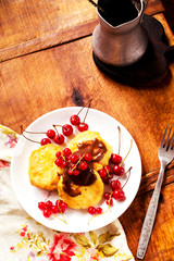 Cheese pancakes served in plate and coffee pot on table