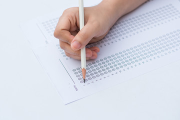 woman's hands filling in standardized test form