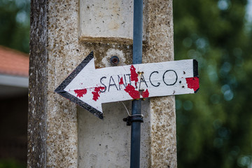 Weisser Pfeil mit Aufschrift Santiago am Jakobsweg in Spanien