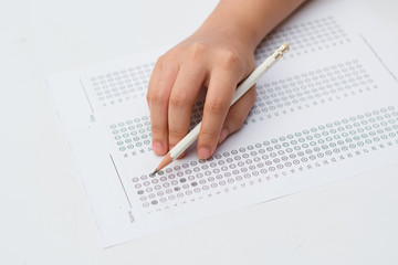 woman's hands filling in standardized test form