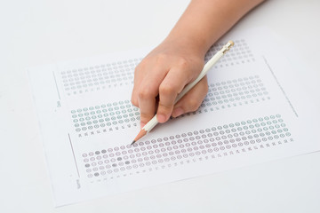 woman's hands filling in standardized test form