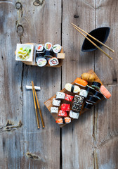A variety of sushi and green tea set on rustic wooden table.