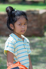 little asian girl look at right side while she in outdoor park.