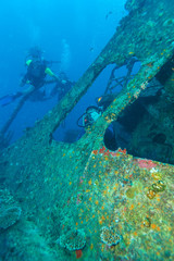 Fototapeta na wymiar Group of scuba divers near a sunken ship in the Maldives