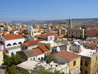 Obraz premium Greece, Crete. Panorama of Chania old town aerial view. Old houses with red roofs, Cathedral and Catholic church. On rear background are mountains and sea.