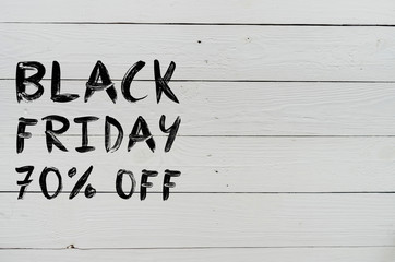 Black friday 70% off brush hand lettering on white painted rustic barn wooden planks. Sale banner template. Space for copy, text, lettering.