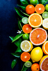 Assorted fresh citrus fruits with leaves. Background