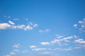 Small cloud group in clear sky background.