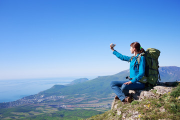 Young female traveller with packpack at mountain lanscape makes