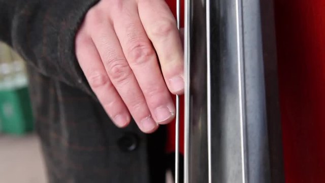 Musician plays a double bass, upright bass, close up on fingers and strings.