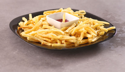French fries on the plate standing the wooden table