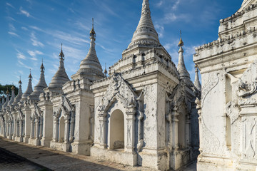 Obraz premium Sandamuni Pagoda with row of white pagodas. Amazing architecture of Buddhist Temples at Mandalay. Myanmar (Burma) travel landscapes and destinations