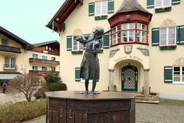 Statue of Mozart near the Town Hall during a snowfall. Alpine village Sankt-Gilgen, Austria. 