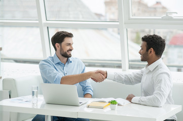 Employees of creative team shaking hands