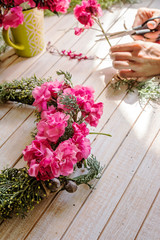 Florist at work: Creating a wooden wreath with flowers. christma