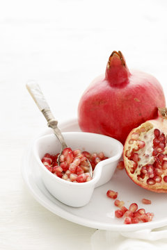 Pomegranate Seeds , some peeled and whole on a white background