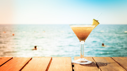 Concept of tropical vacation. Exotic cocktail on the pier. Luxur