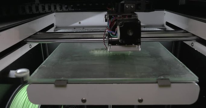 Close-up view of moving mechanism of 3d printer making pieces with white plastic. Innovation in printing process