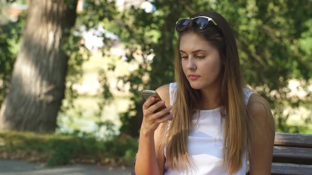 young woman on a Park bench using your phone