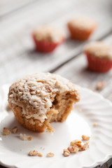 Walnut crumb sweet potato muffin on an antique china plate with a bite taken out of it