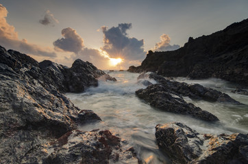 Fototapeta na wymiar beautiful waves splashing on unique rocks formation at Pandak Be