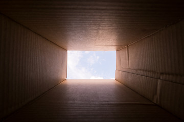 Concept image "Thinking Outside the Box" - Inside a cardboard with clear sky