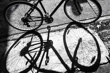 Fototapeta na wymiar Black and white a bicycle against shadow 