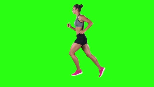 Woman running in sport clothing. Side view. Green screen. Slow motion