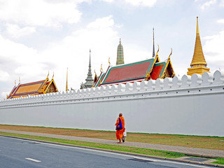Naklejka premium Monk walking pass Royal palace's wall, Thailand