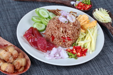 Fried jasmine rice with shrimp paste,(Kao Klok Kapi in Thai) served with green mango,Chinese sausage,crispy dried fish,shrimp,minced chili,shallots,stir sweet pork,cucumber and egg.Selective focus.
