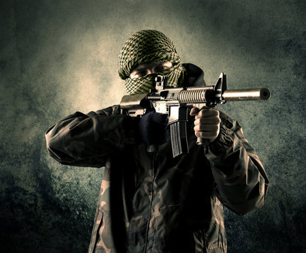 Portrait of a heavily armed masked soldier with grungy backgroun