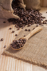Coffee beans in spoon on sack