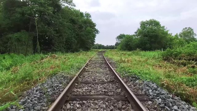 Walk along abandoned railway beside the forest in first person view
