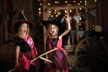 Two little girls laughing witch on a broomstick. childhood Hallo