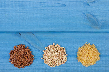 Heap of various groats on wooden boards, healthy food and nutrition, copy space for text