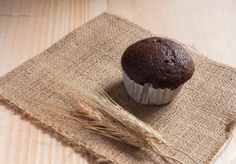 Cupcake on fabric  with  wooden background.