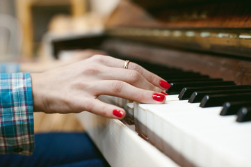 hipster girl playing a vintage white piano