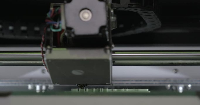 Extreme close-up view of mechanism of 3d printer in process. It makes object with white plastic