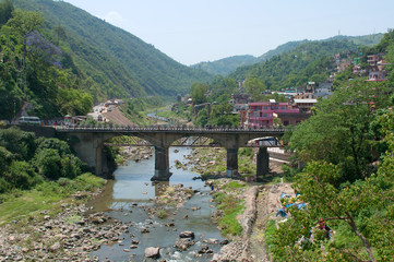 Fototapeta na wymiar Road bridge over the river in the city of Saket Mandi. Himachal Pradesh