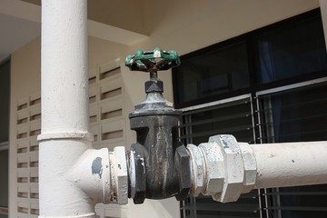 Close up  Water valve, The rust Water valve, and pipe outside a building 